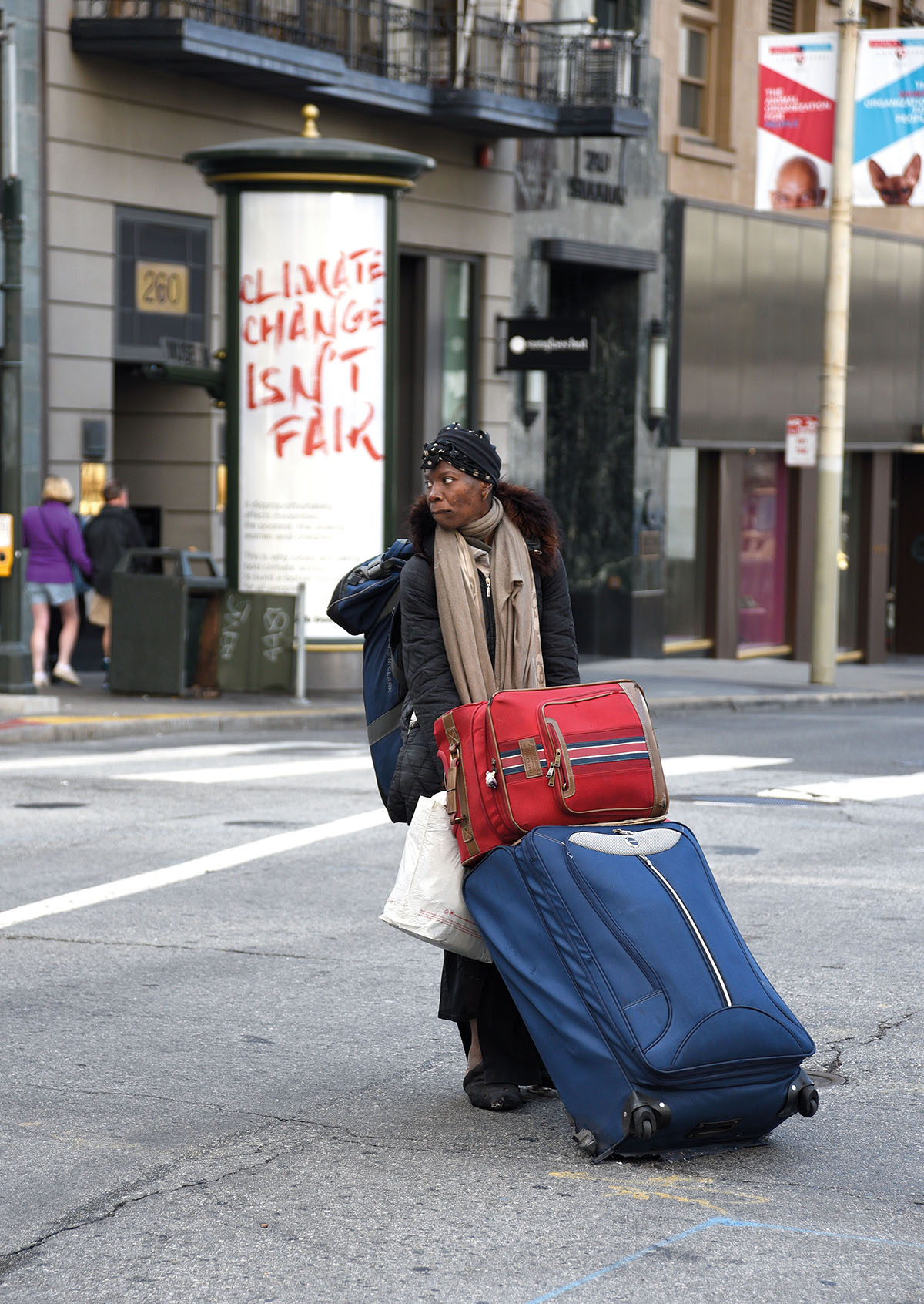 SAN FRANCISCO, CALIFORNIA - SEPTEMBER 12, 2018: A woman drags her possessions packed into suitcases and a backpack across a busy intersection in San Francisco, California. (Photo by Robert Alexander/Getty Images)