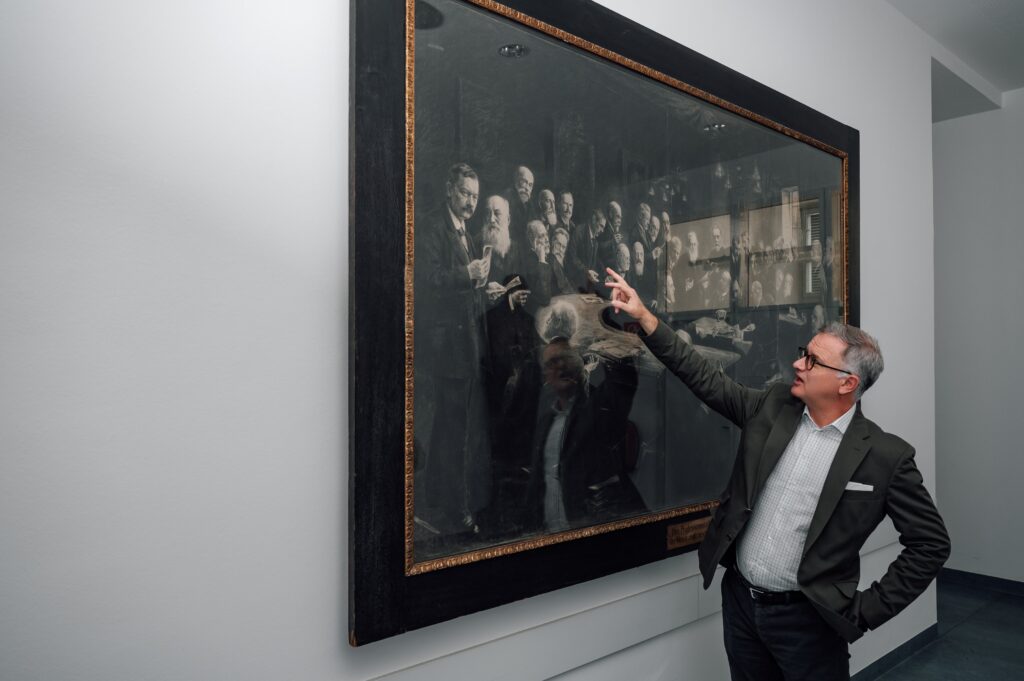 Berühmte Vorgänger: Prof. Müller vor dem Bild des Professorenkollegiums der Wiener Medizinischen Fakultät (Foto: CALL Magazine/Anna Raisa Illic)